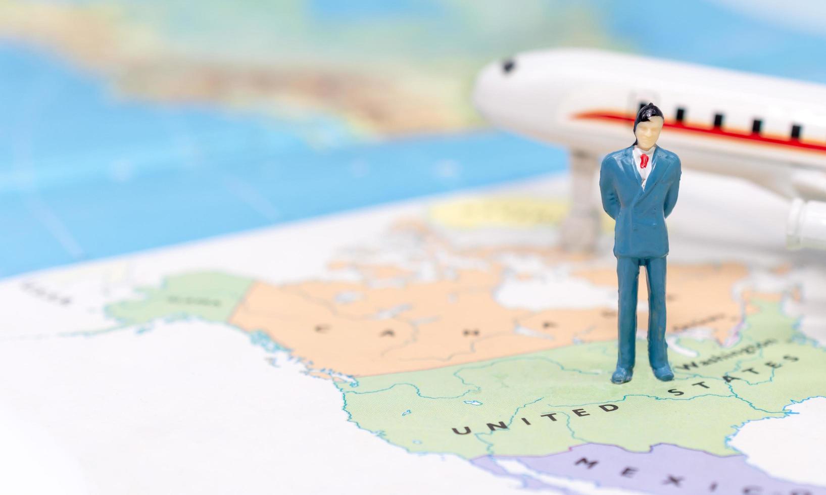 Miniature people, businessman standing on map American photo