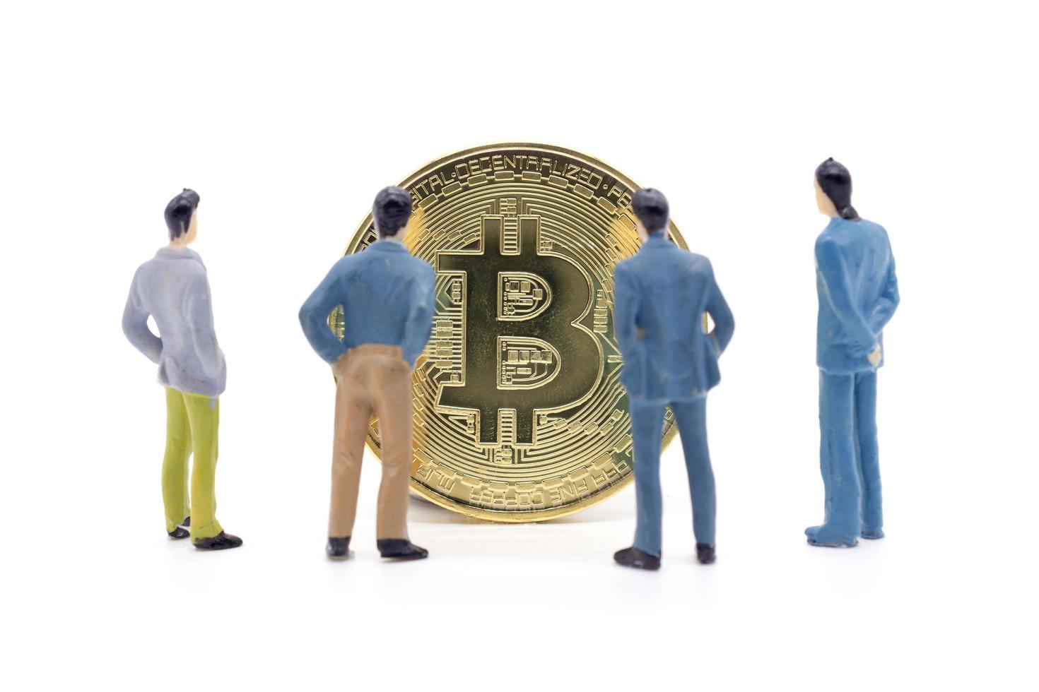Miniature businessman and Bitcoin on white background photo