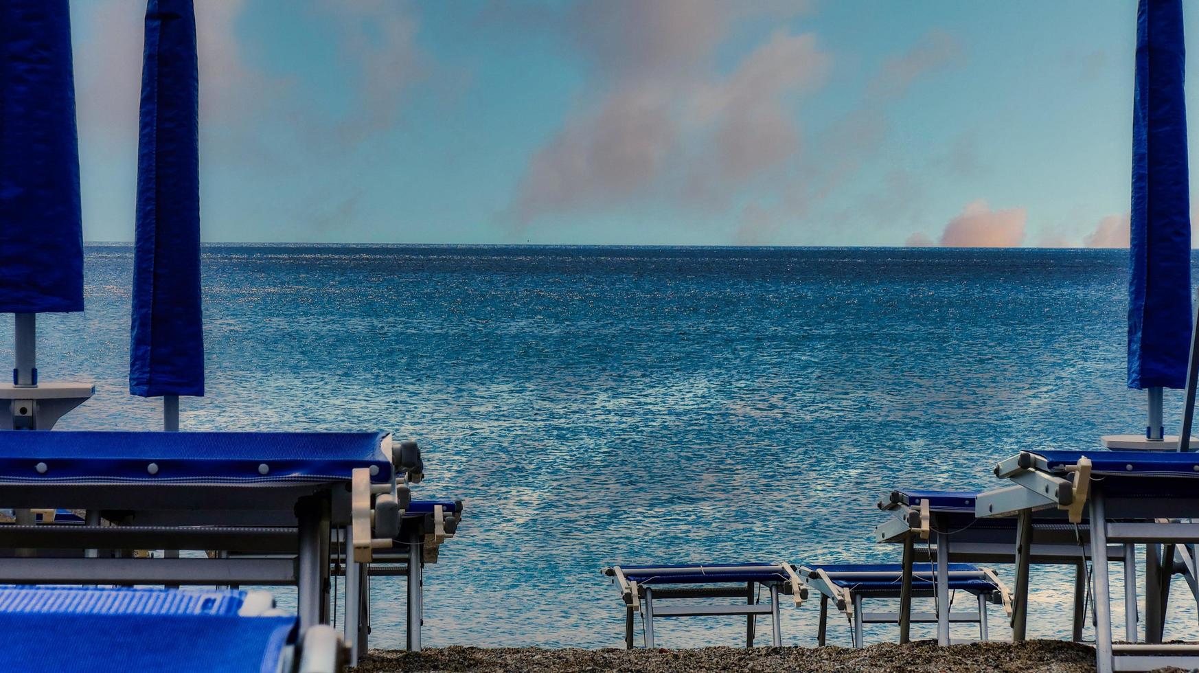 deckchairs on the sandy beach near the sea in July, in Spotorno on the western Ligurian Riviera photo