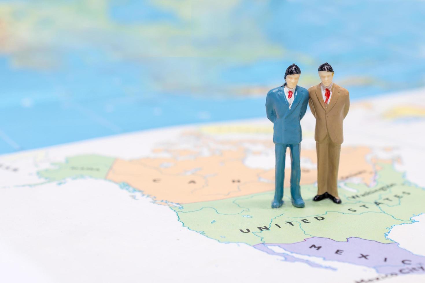 Miniature people, businessman standing on map American photo