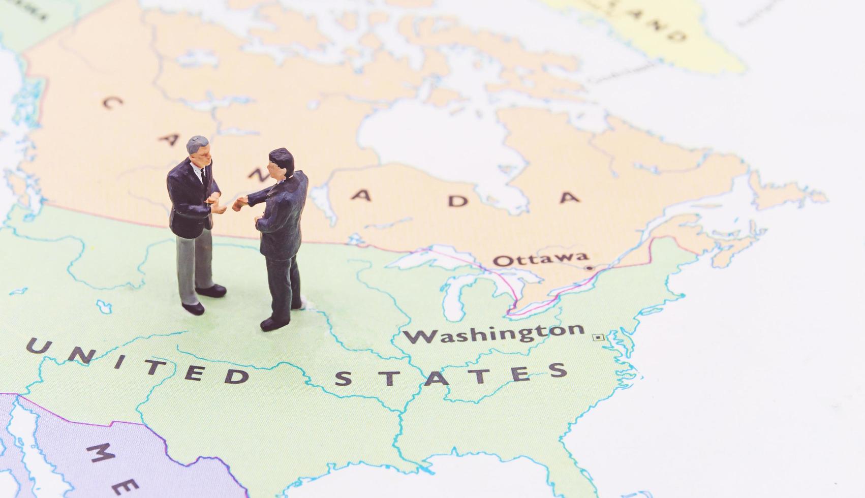 Miniature people, businessman standing on map American photo