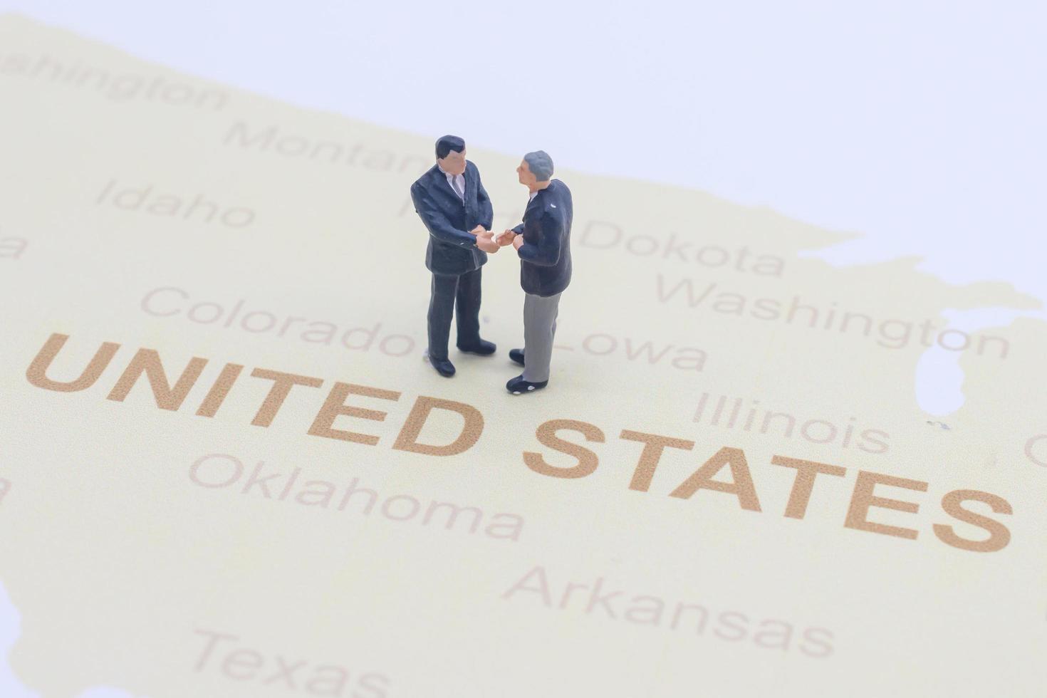 Miniature people, businessman standing on map American photo