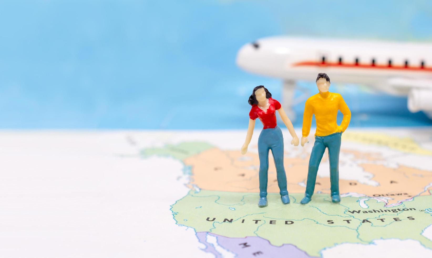 gente en miniatura, pareja de pie en el mapa americano foto