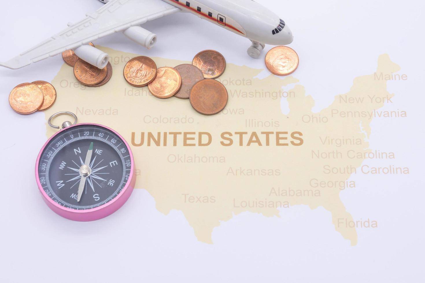 passport compass and coins on a American map. business travel concept photo