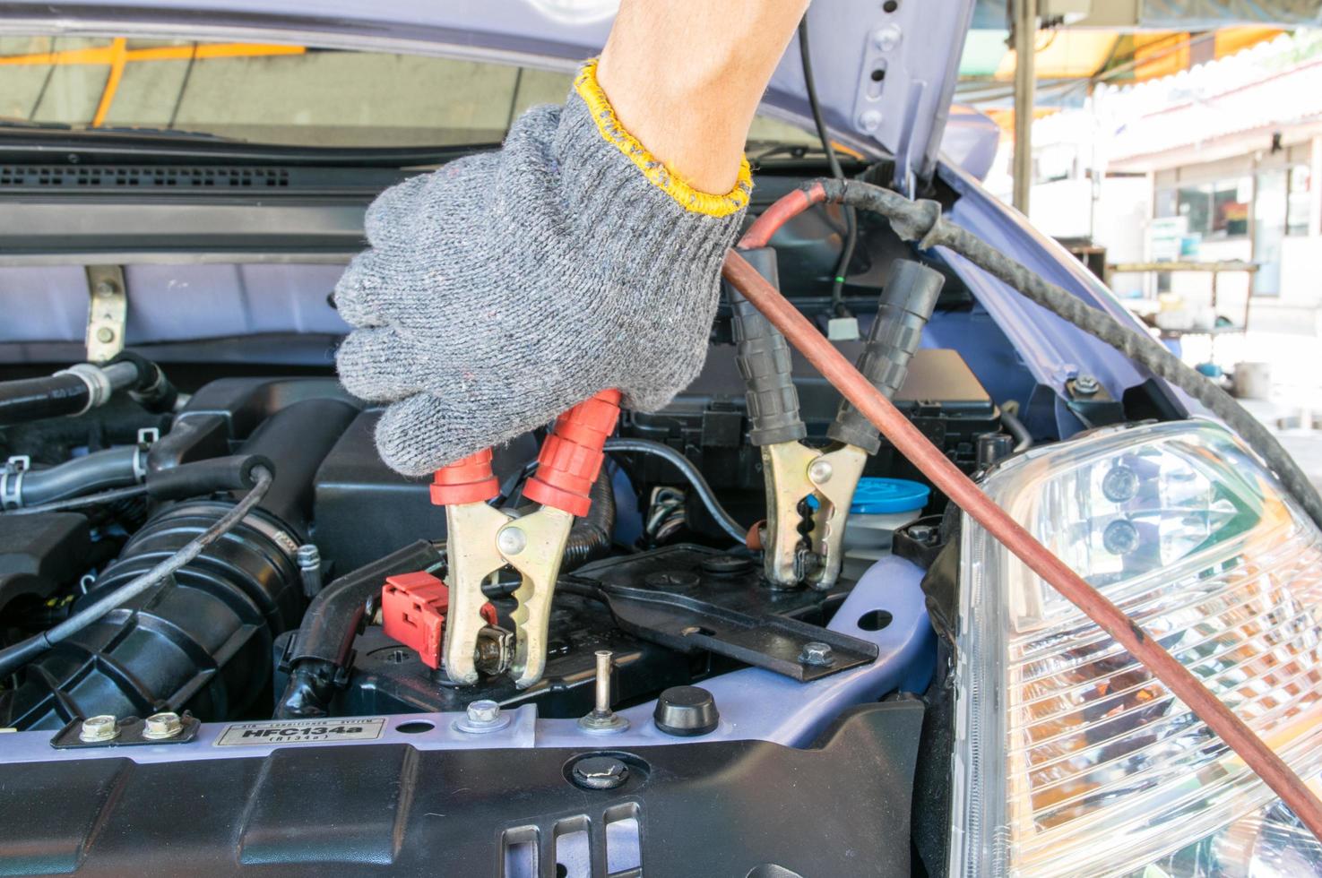 técnico automotriz cargando la batería del vehículo foto