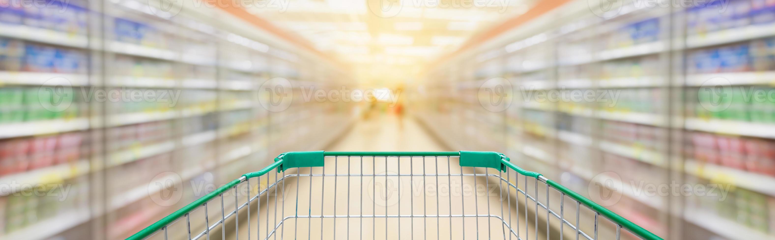 Shopping cart with supermarket aisle blur background photo