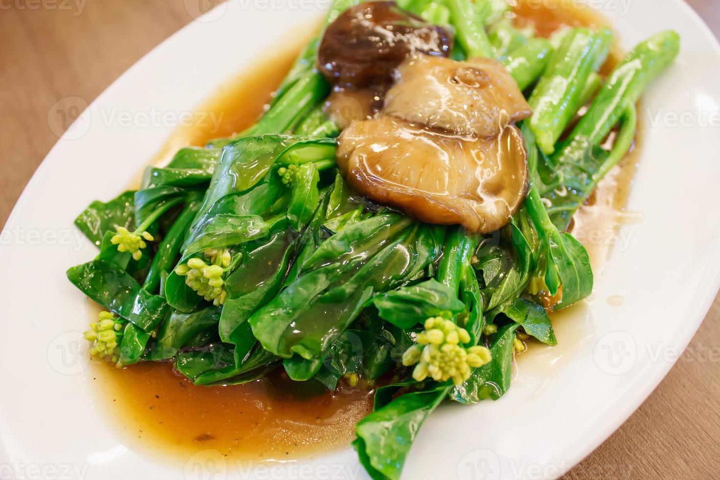 Stir-fried chinese broccoli and shiitake mushroom in oyster sauce photo