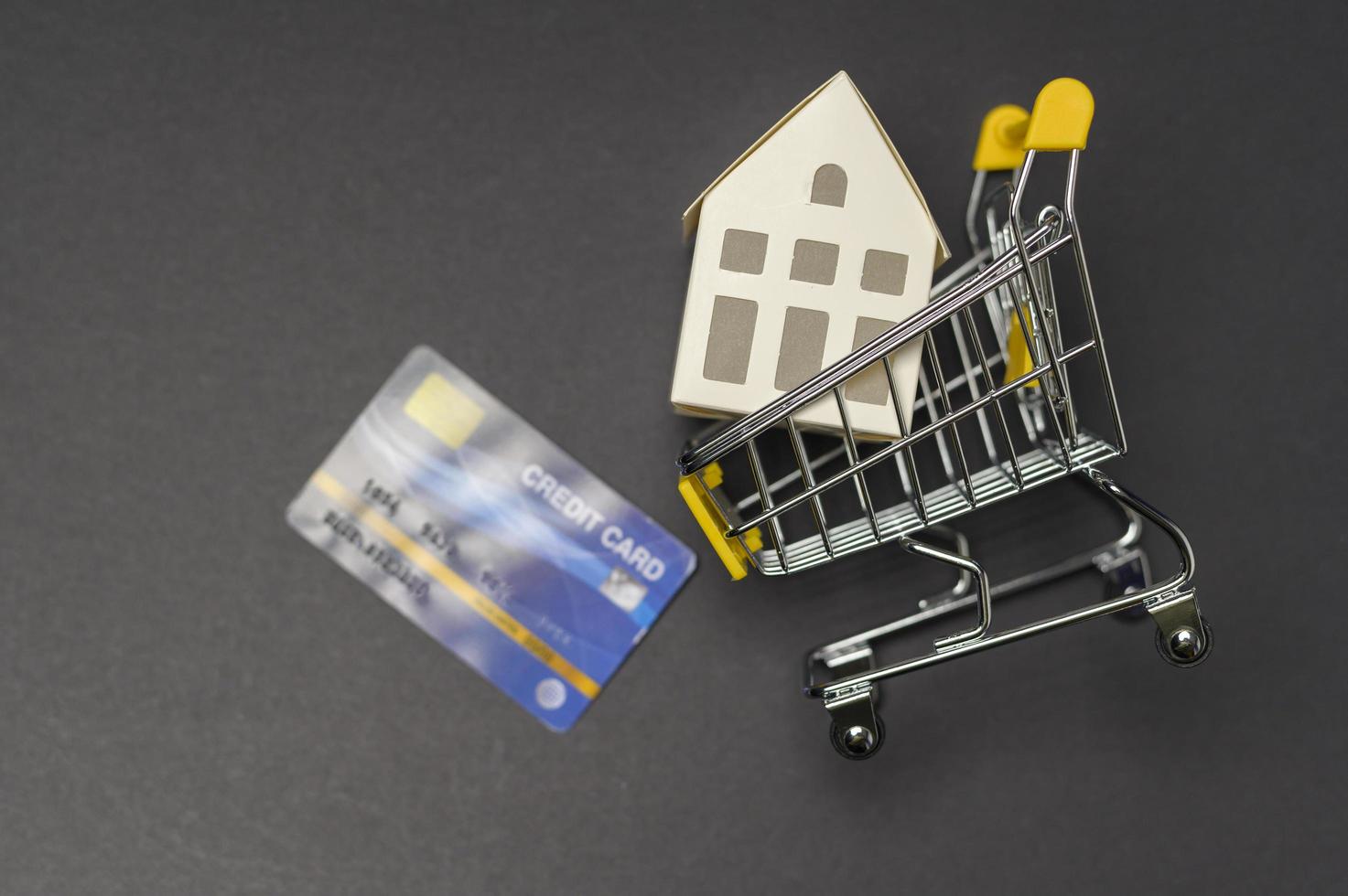 Small white model home over black background studio photo