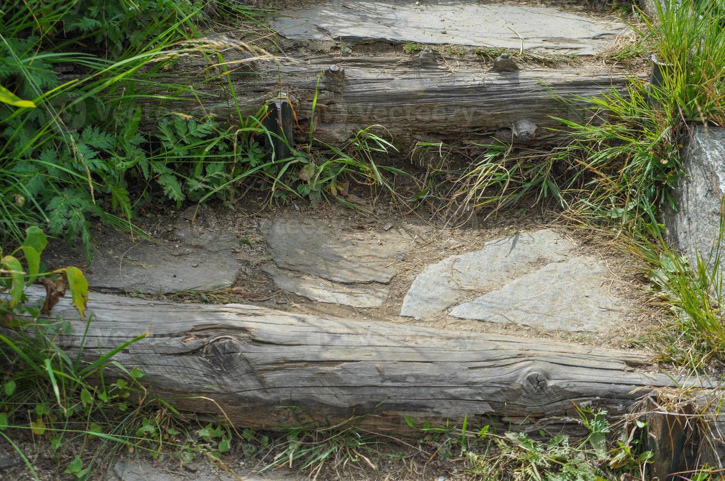 Old stone and wood steps in a mountain path photo
