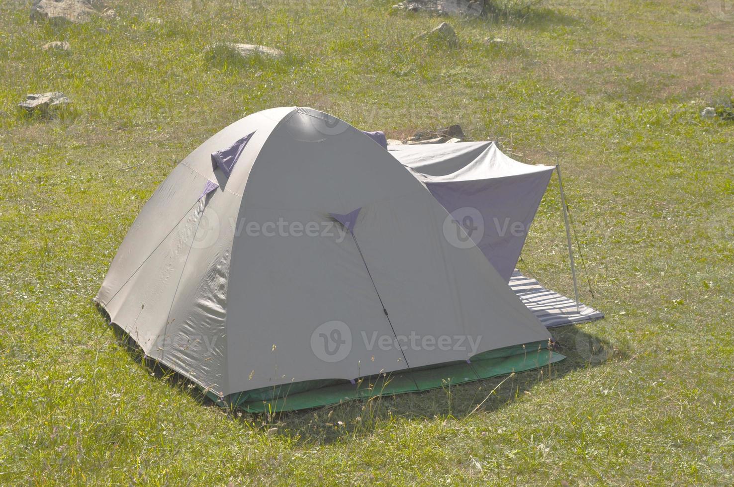 A fabric camping tent shelter in a field photo