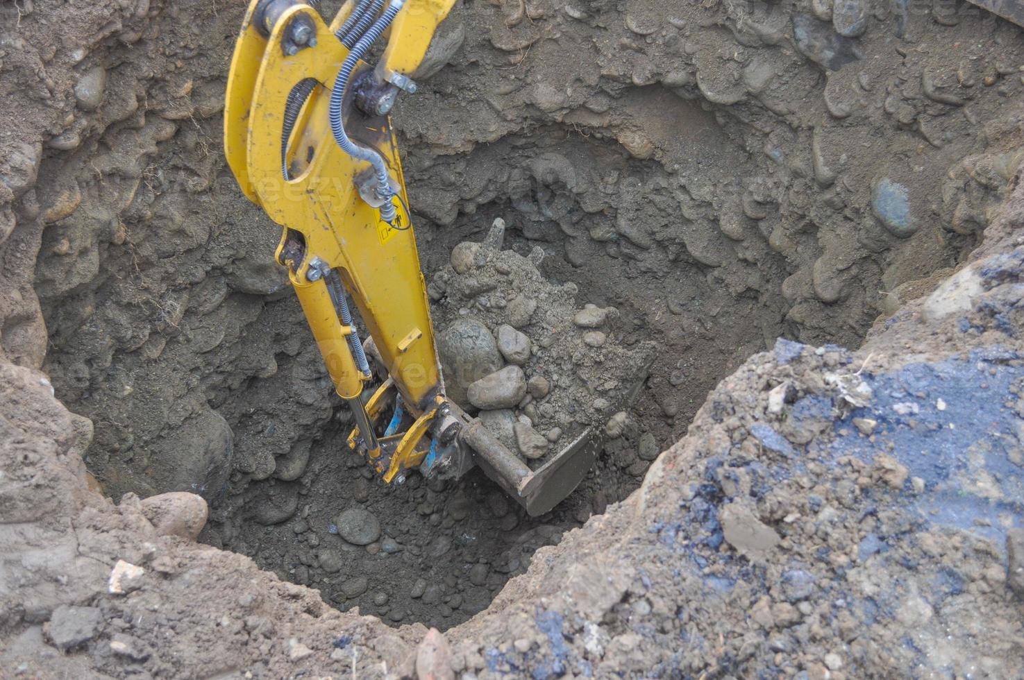 Excavator digging a hole photo