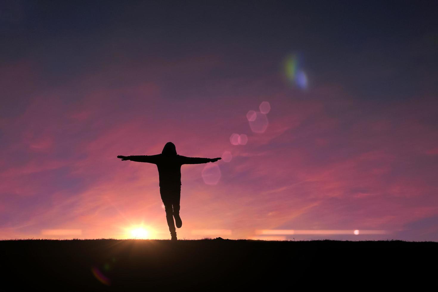 adult man silhouette in the mountain with a romantic sunset background photo