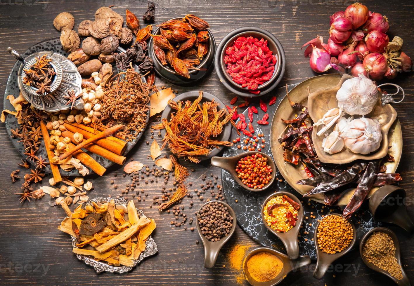Top view Herbs for cooking, such as red curry, stewed or tom yum soup, such as shallots, garlic, dried chilies, chili peppers, coriander balls, goji berries or goji berries, turmeric powder, turmeric. photo