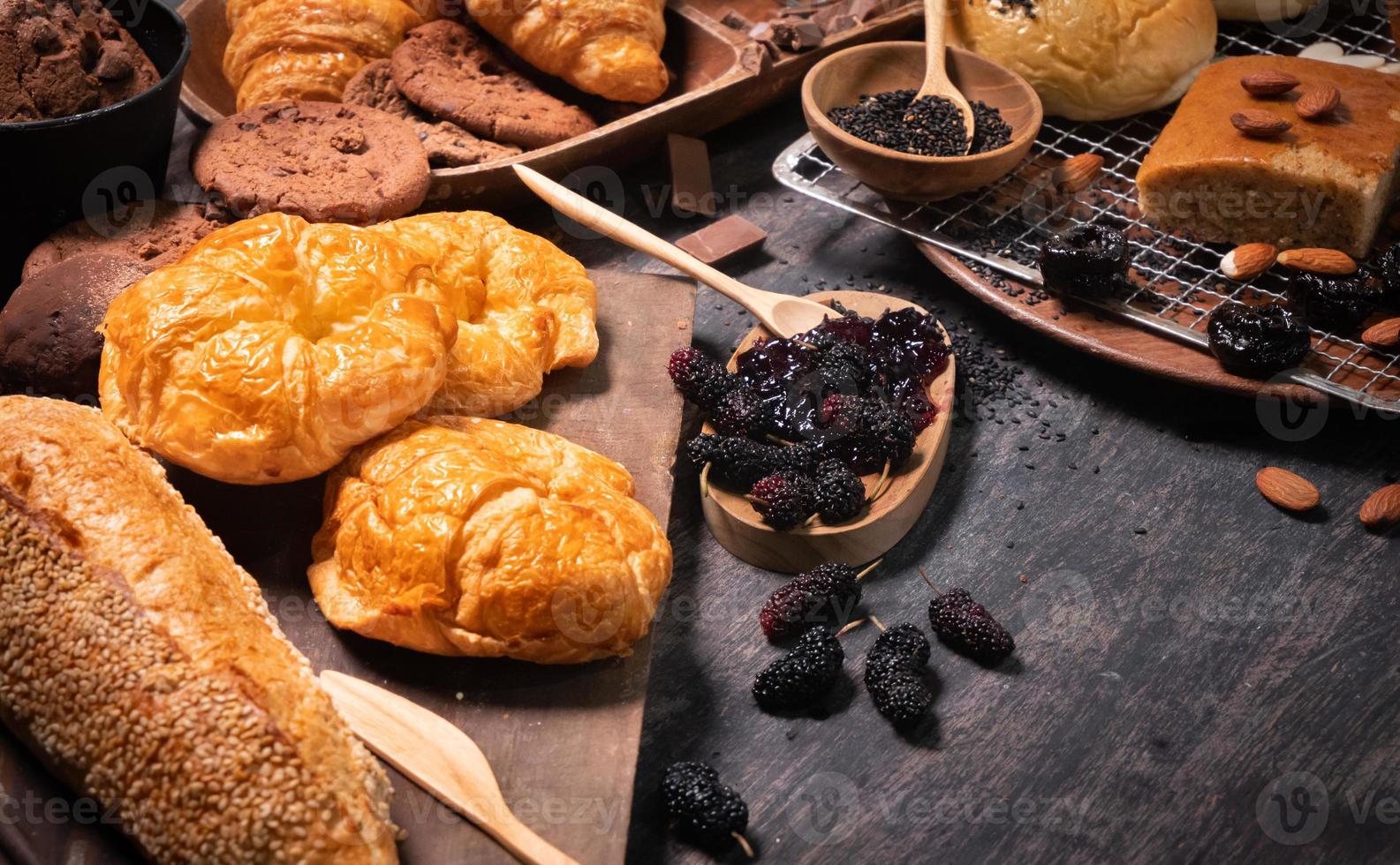 postres de panadería populares como croissants, galletas en ideas de mesa para postres o para hornear. hornear panadería con mermelada de bayas, almendras y semillas de amapola. foto