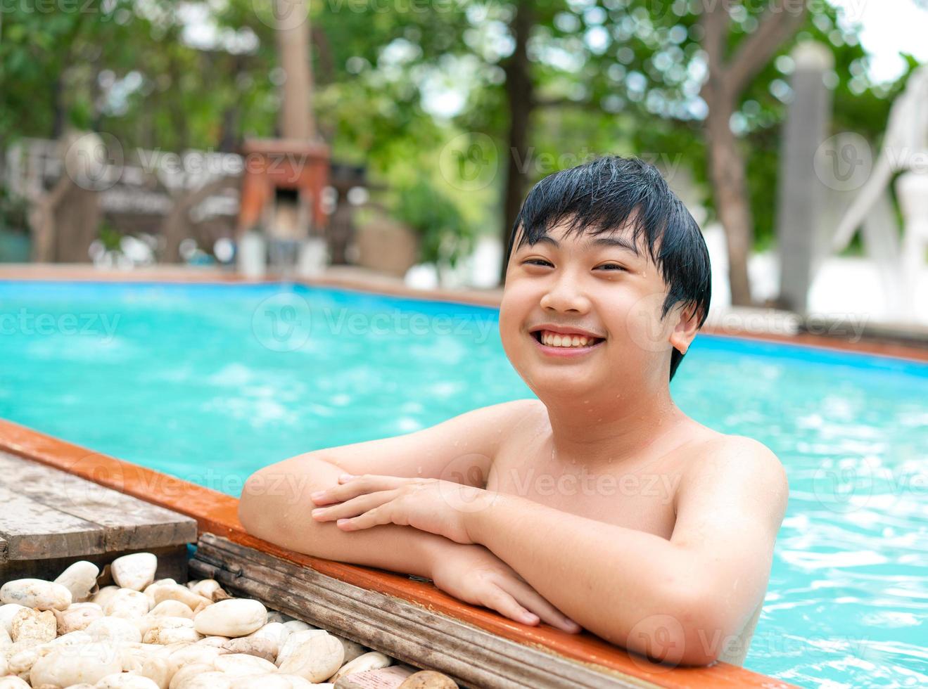 Teenage smile and swimming in the  pool on summer holiday photo