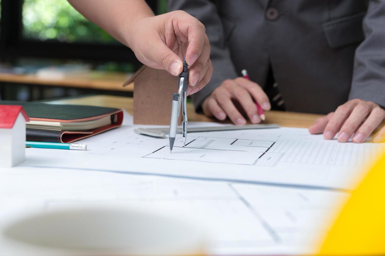 Hands of architect or engineer using pencil working with blueprint on desk in office . Engineering tools and construction concept. Architect and Business concept.Selective focus,Vintage effect. photo