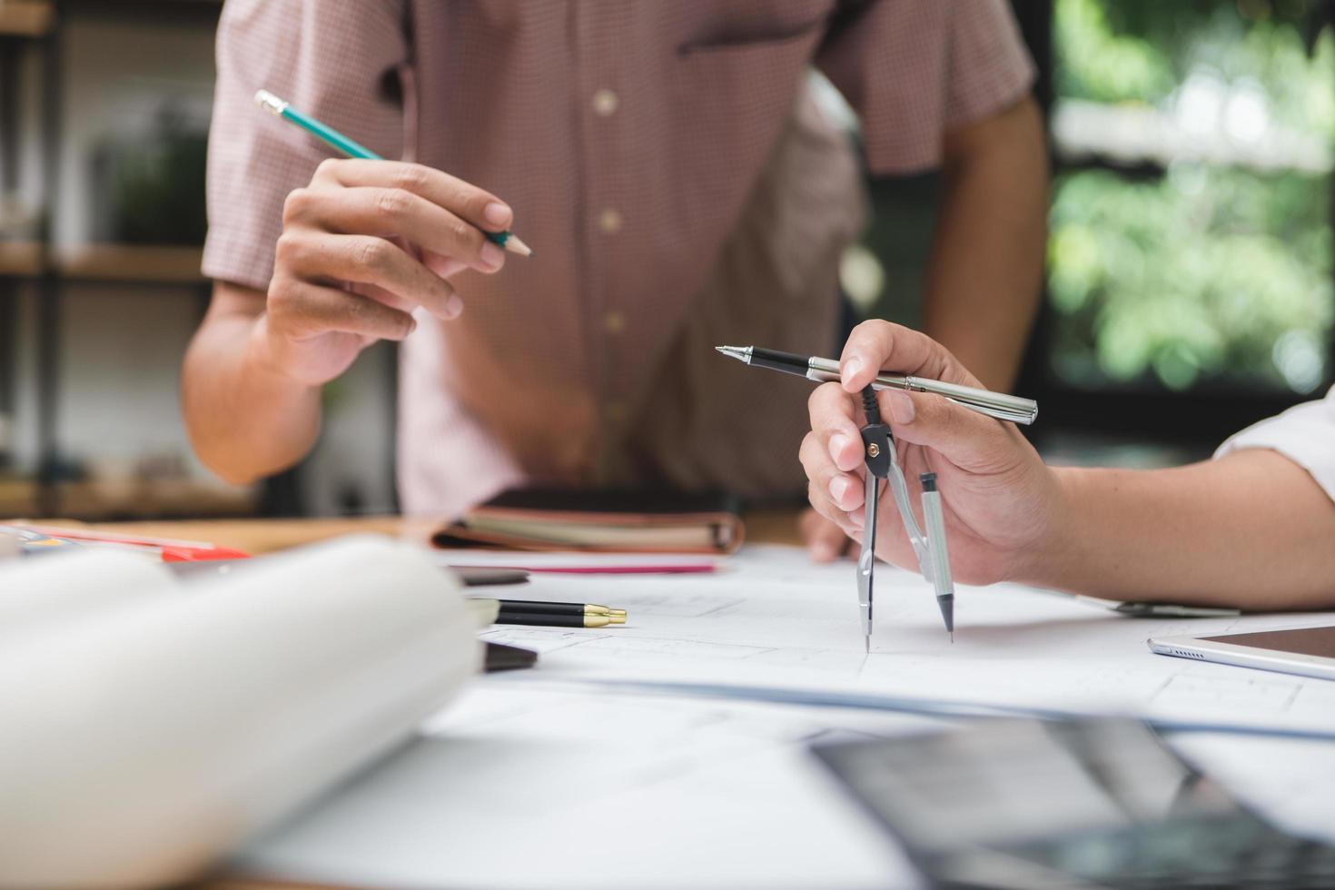 Hands of architect or engineer using pencil working with blueprint on desk in office . Engineering tools and construction concept. Architect and Business concept.Selective focus,Vintage effect. photo