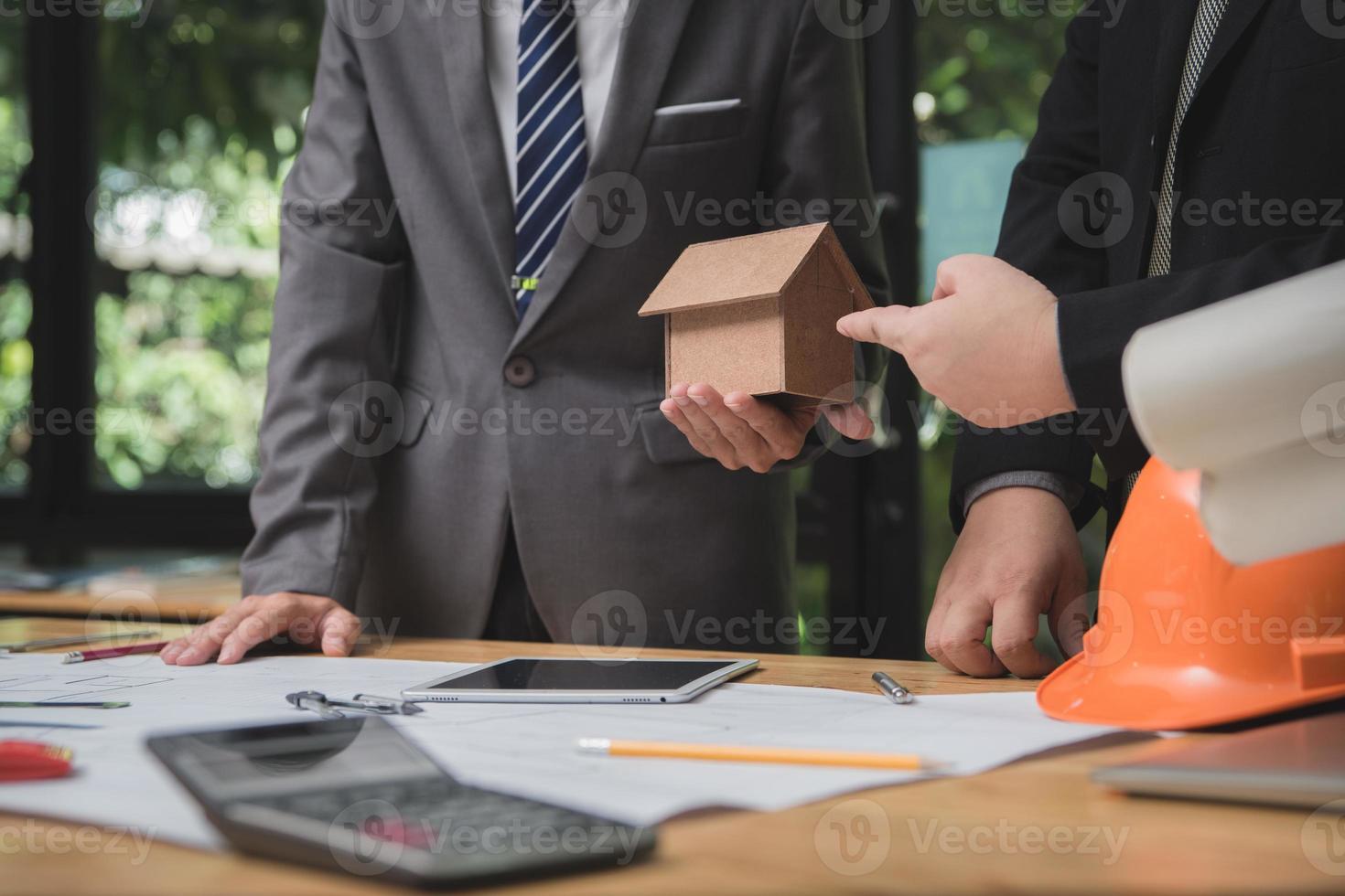 equipo de arquitectos o ingenieros discutiendo en el escritorio con planos sobre el nuevo proyecto de inicio en el escritorio. grupo de equipo en los documentos de verificación del sitio de construcción y el flujo de trabajo comercial. enfoque selectivo. foto