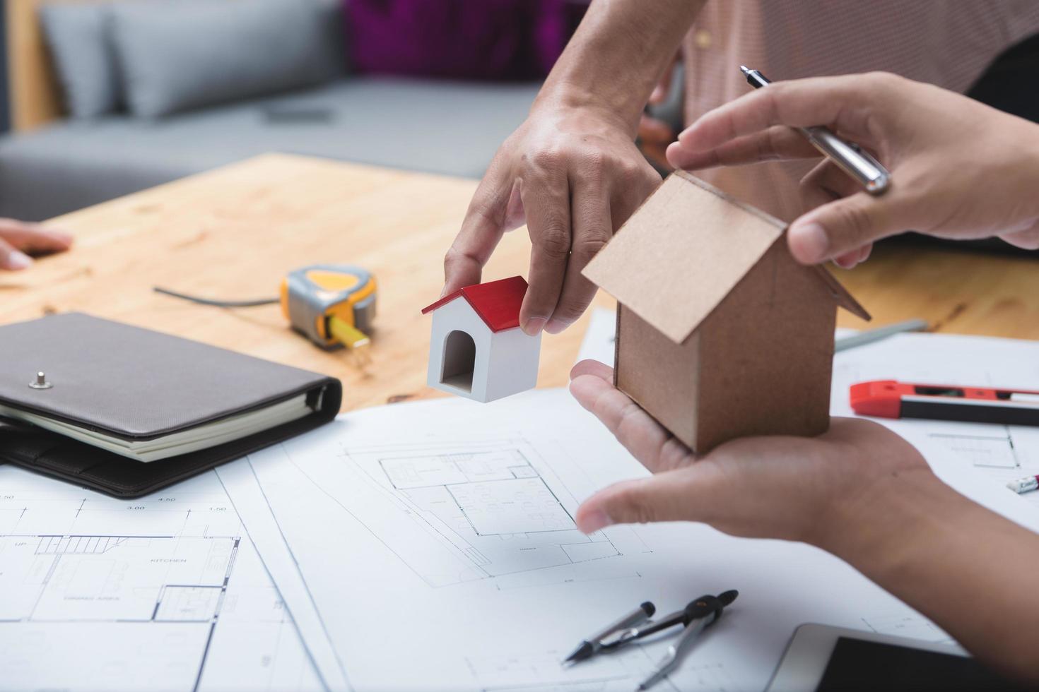 equipo de arquitectos o ingenieros discutiendo en el escritorio con planos sobre el nuevo proyecto de inicio en el escritorio. grupo de equipo en los documentos de verificación del sitio de construcción y el flujo de trabajo comercial. enfoque selectivo. foto