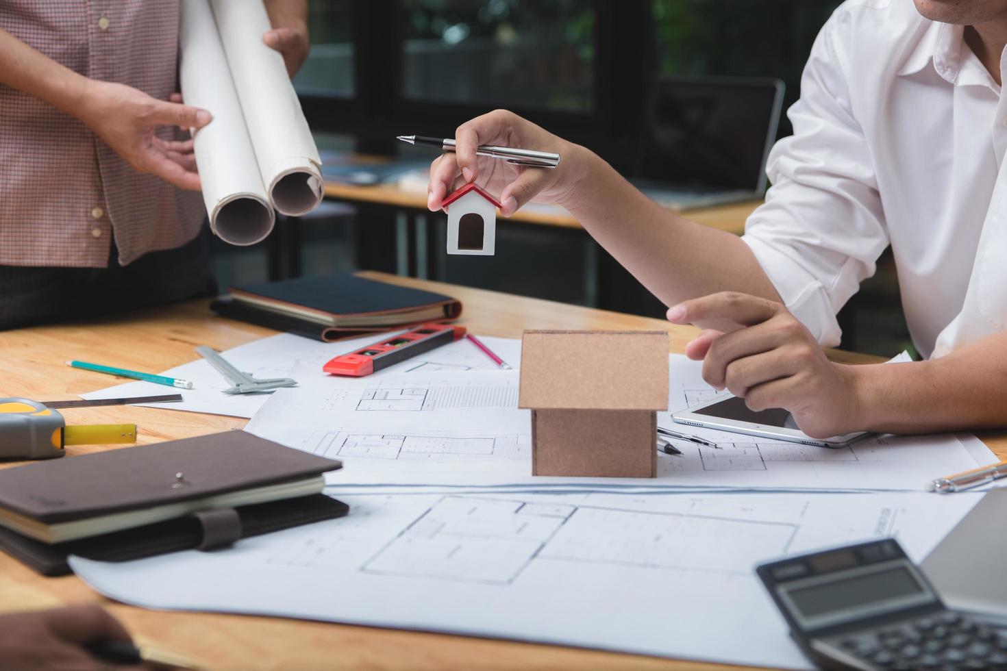 Team of architects or engineer discussing on desk with blueprint about new startup project on desk. Team group on construciton site check documents and business workflow.Selective focus. photo