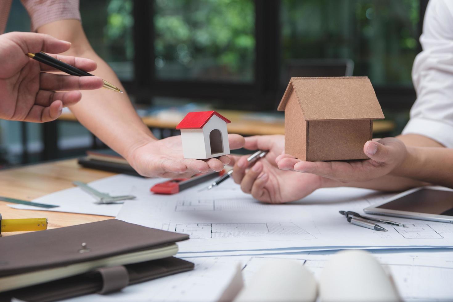 equipo de arquitectos o ingenieros discutiendo en el escritorio con planos sobre el nuevo proyecto de inicio en el escritorio. grupo de equipo en los documentos de verificación del sitio de construcción y el flujo de trabajo comercial. enfoque selectivo. foto