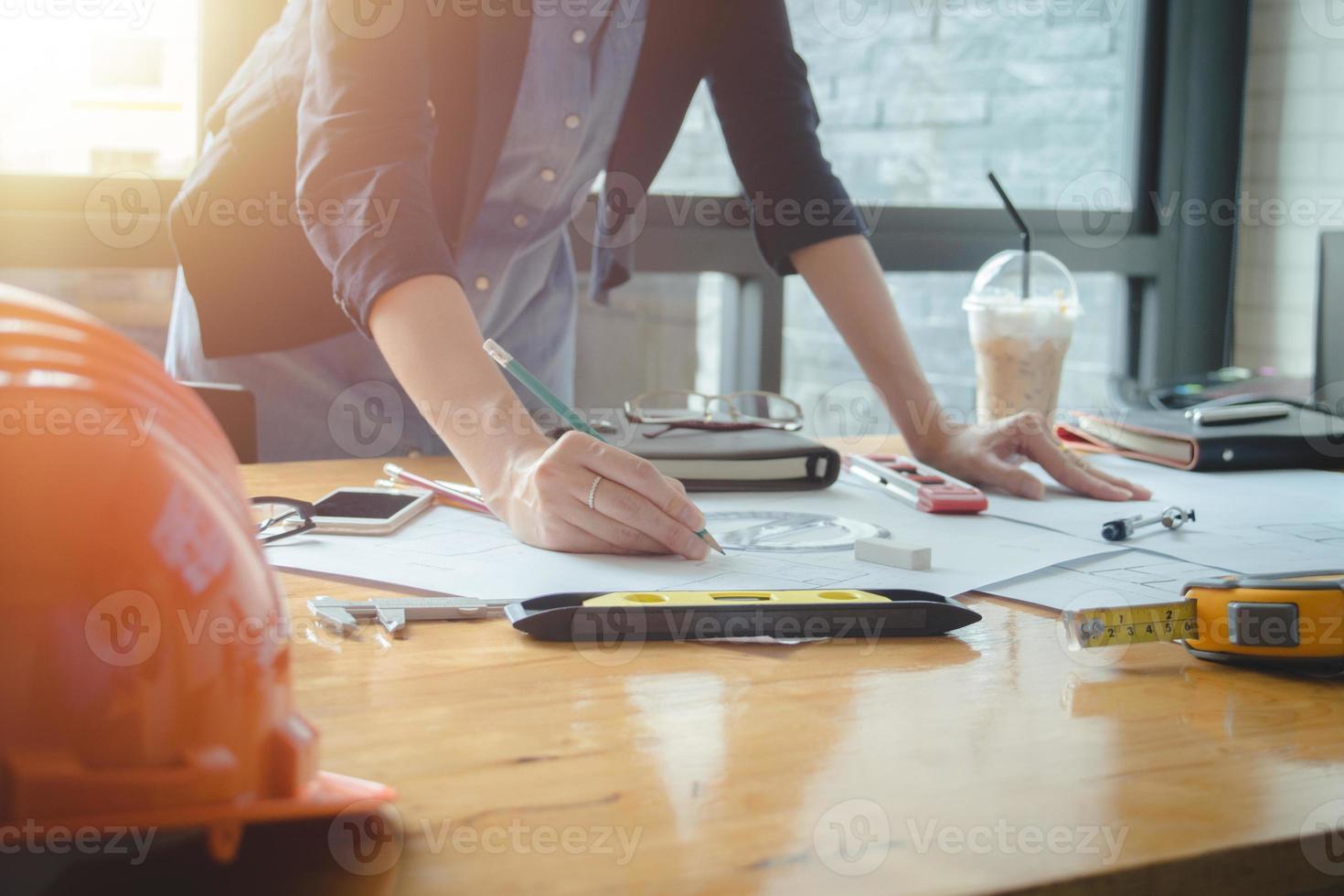 mujer arquitecta sola que trabaja con brújulas y planos para el plan arquitectónico, ingeniera que esboza un concepto de proyecto de construcción.concepto de arquitecto,efecto vintage foto