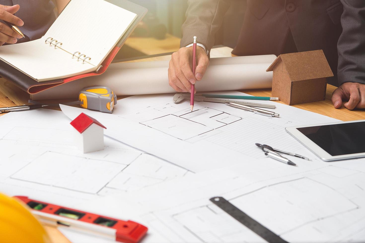 Hands of architect or engineer using drawing compass with blueprint on desk in office.Team of architects engineer discussing and check documents and business workflow.Construction concept. photo