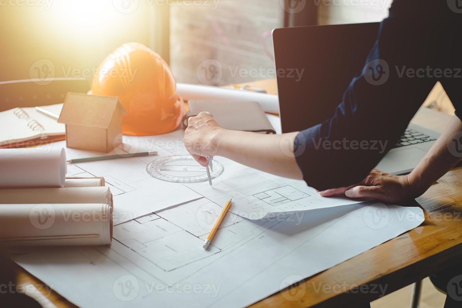 Alone architect woman working with compasses and blueprints for architectural plan,engineer sketching a construction project concept.Architect concept,Vintage Effect photo