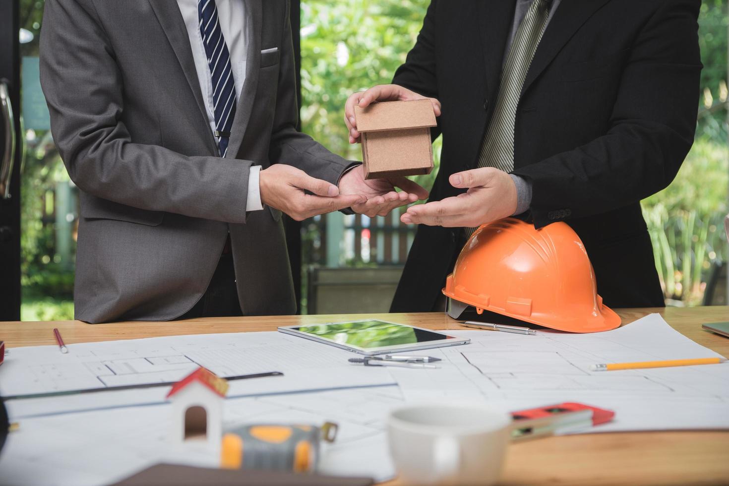 equipo de arquitectos o ingenieros discutiendo en el escritorio con planos sobre el nuevo proyecto de inicio en el escritorio. grupo de equipo en los documentos de verificación del sitio de construcción y el flujo de trabajo comercial. enfoque selectivo. foto