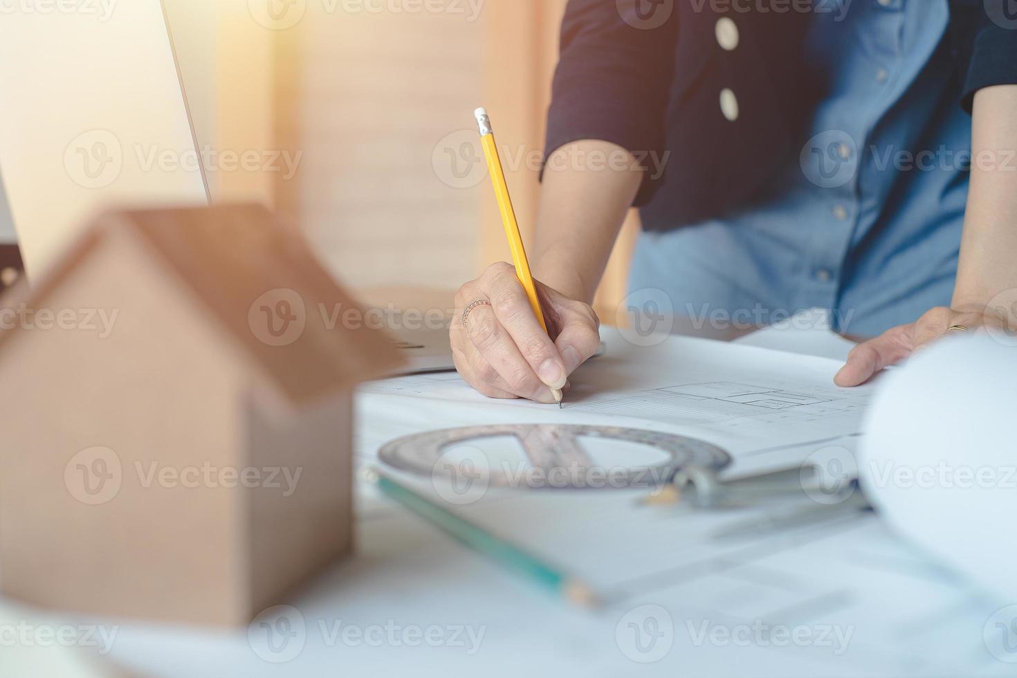 mujer arquitecta sola que trabaja con brújulas y planos para el plan arquitectónico, ingeniera que esboza un concepto de proyecto de construcción.concepto de arquitecto,efecto vintage foto