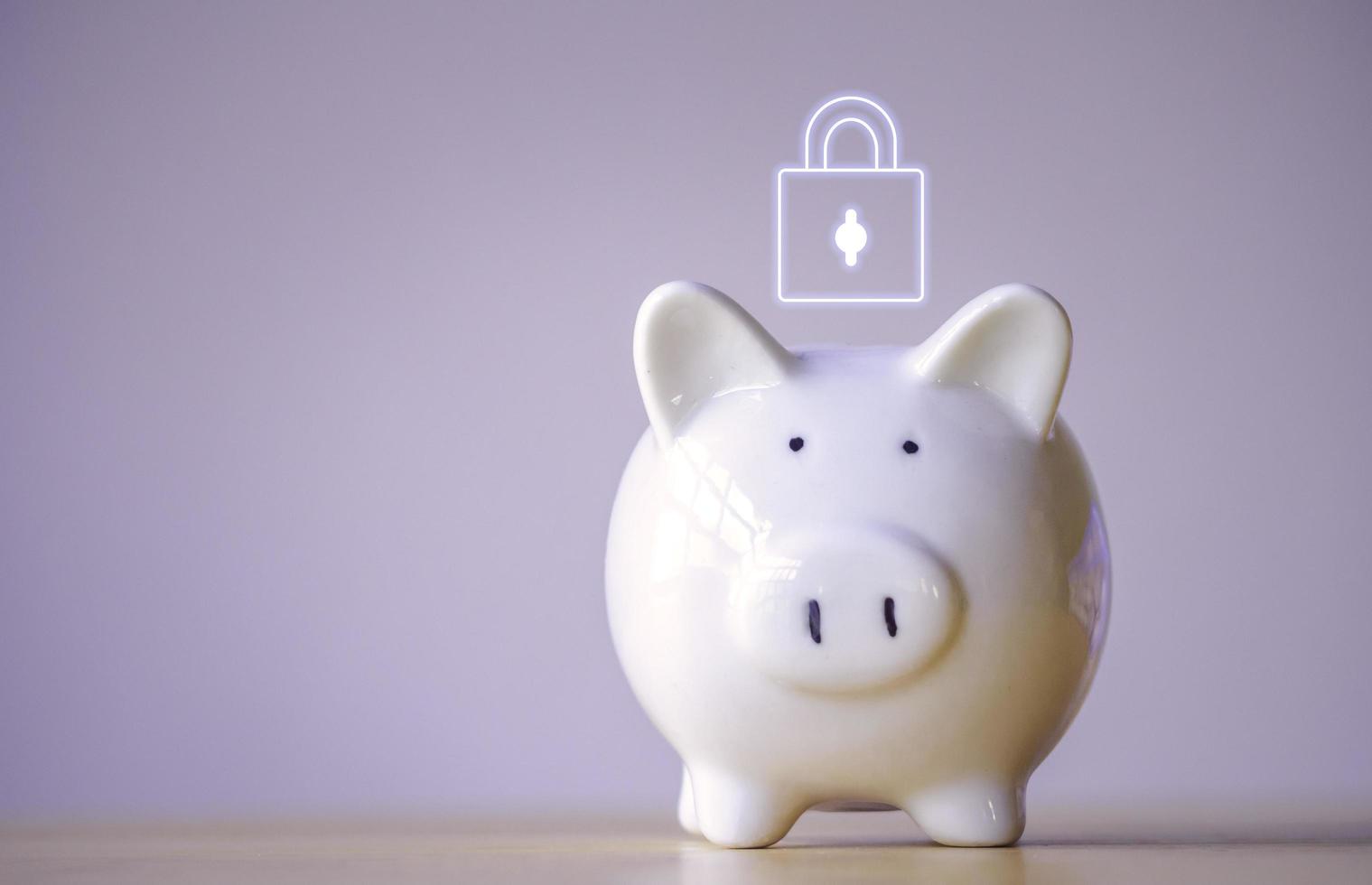 White piggy bank with padlock on top on table to security of money invest for future. Concept for loan, property ladder, financial, real estate investment, taxes and bonus. photo