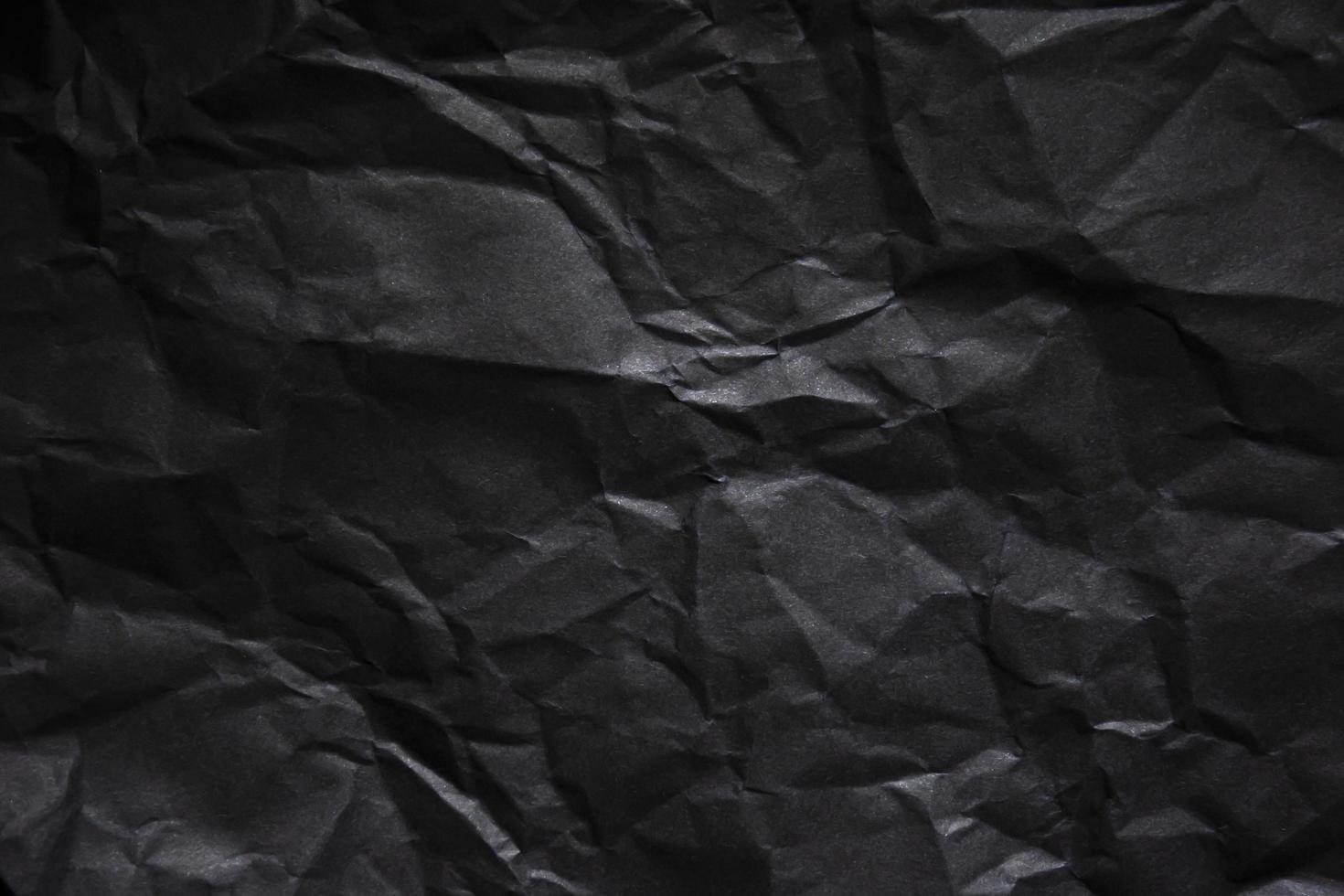 Textured crumpled black paper background. photo