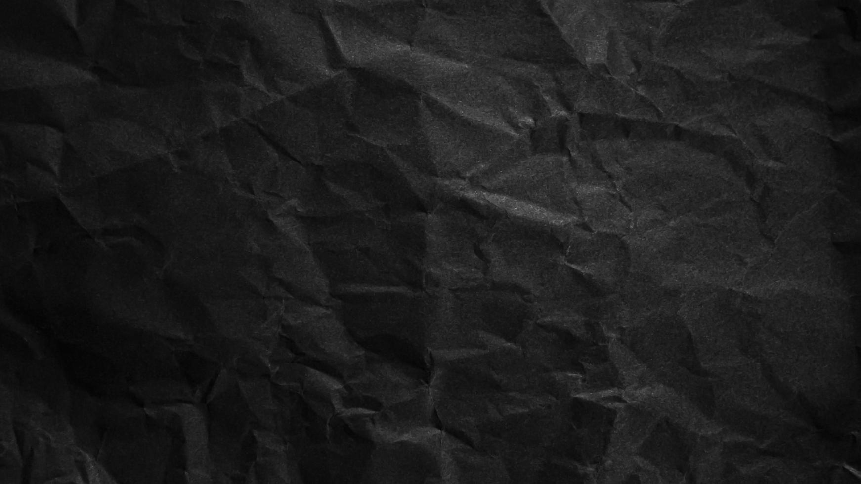 Textured crumpled black paper background. photo