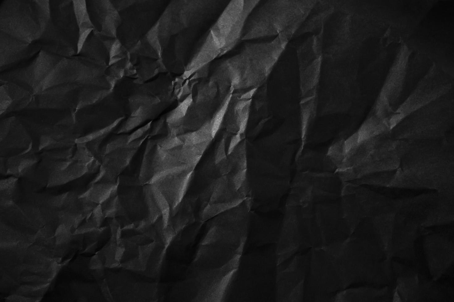 Textured crumpled black paper background. photo