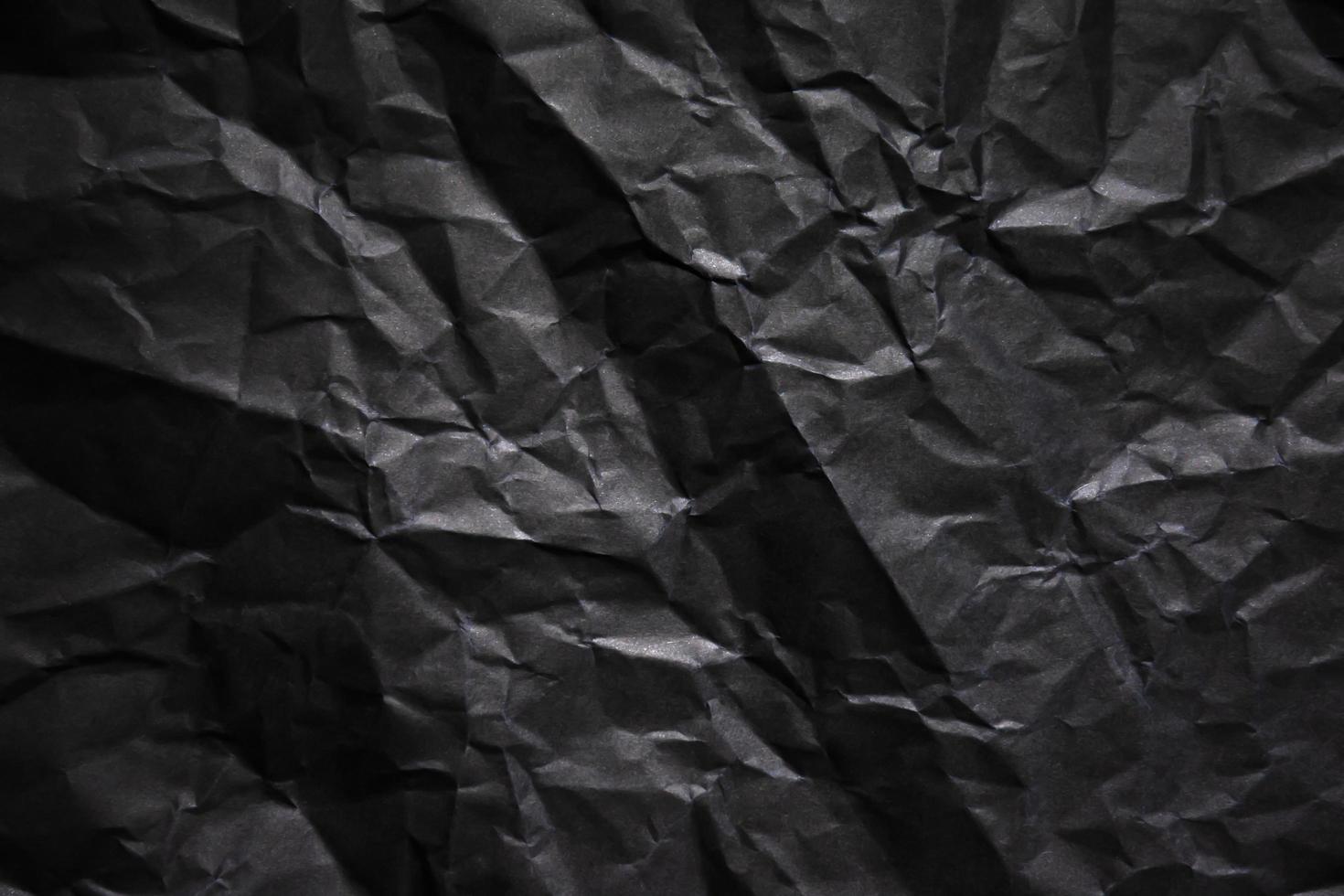 Textured crumpled black paper background. photo