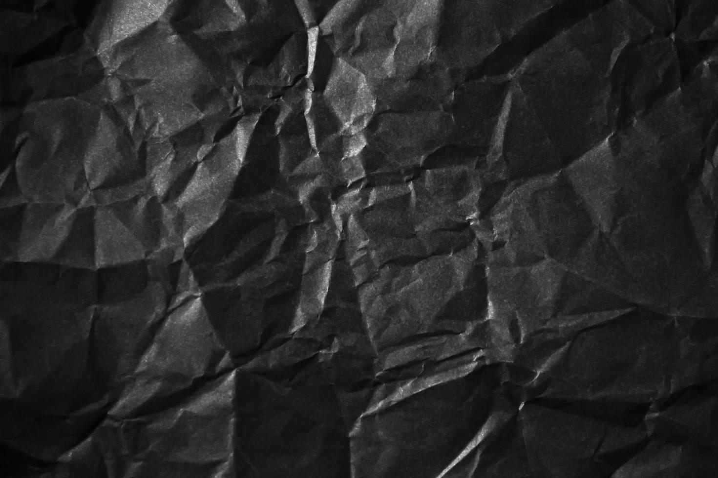 Textured crumpled black paper background. photo