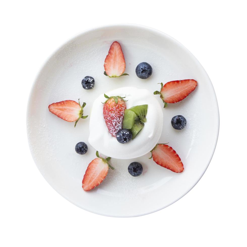 Top view Close-up, Japanese-style pancake topped with mixed fruits, strawberries, kiwi, and blueberries on the top of a cake placed isolated on white background. photo