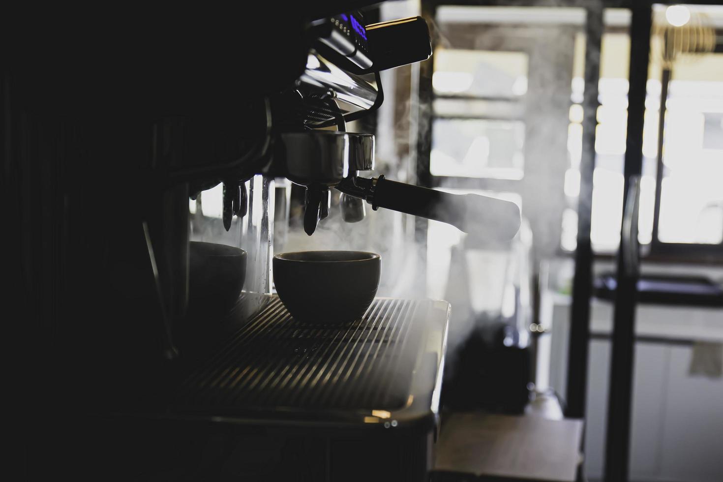 The coffee cup on the machine that is running has steam coming out. photo