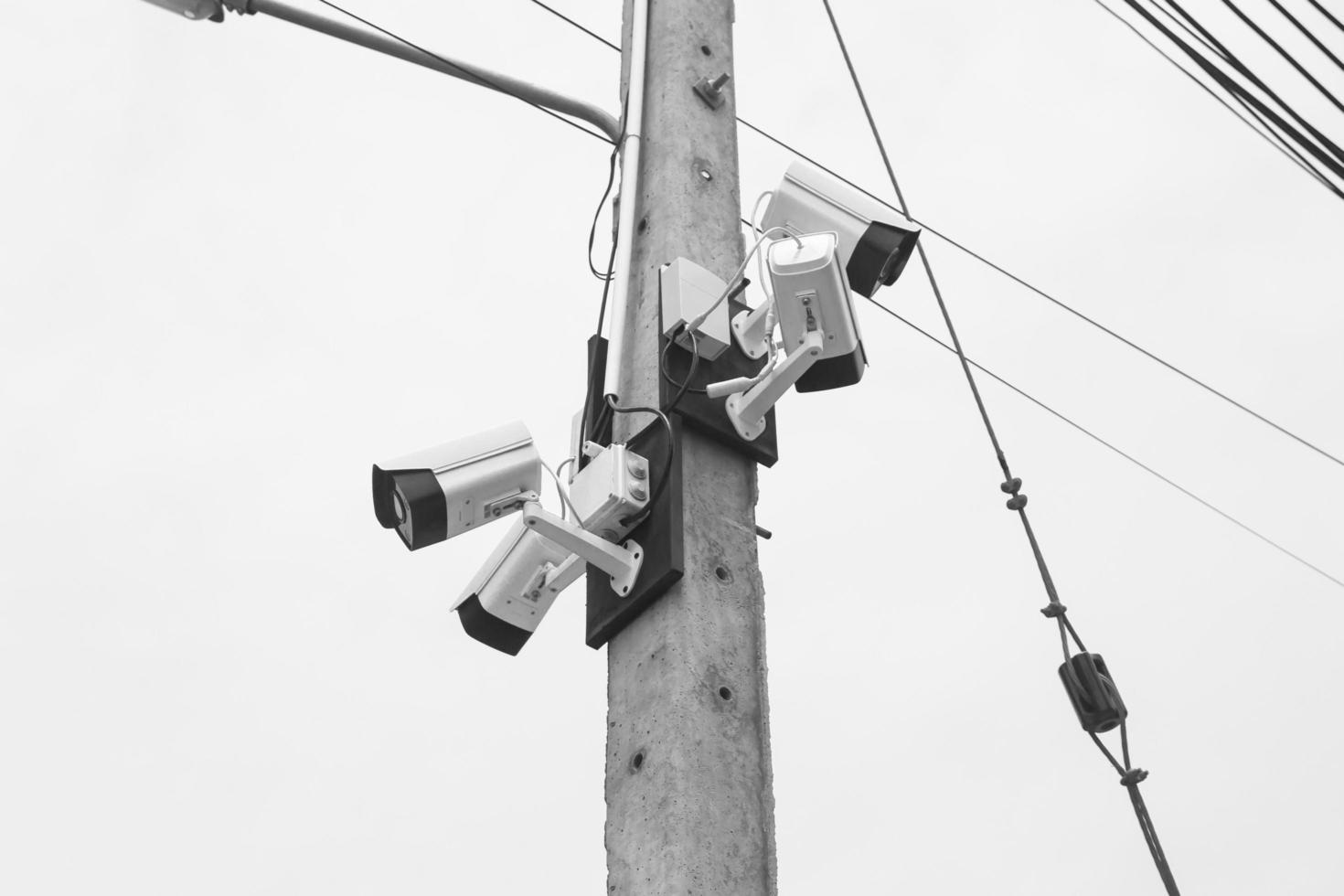 cámaras de vigilancia conectadas a postes eléctricos, tonos blancos y negros foto