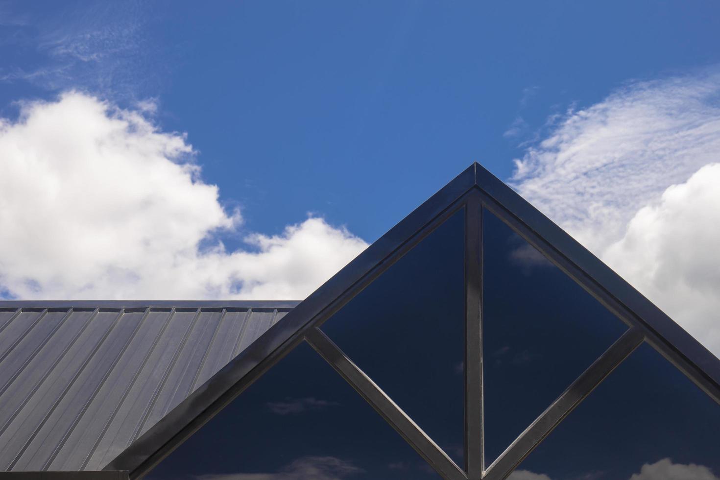 parte del techo triangular de una casa de madera moderna contra el cielo brillante en el fondo. foto