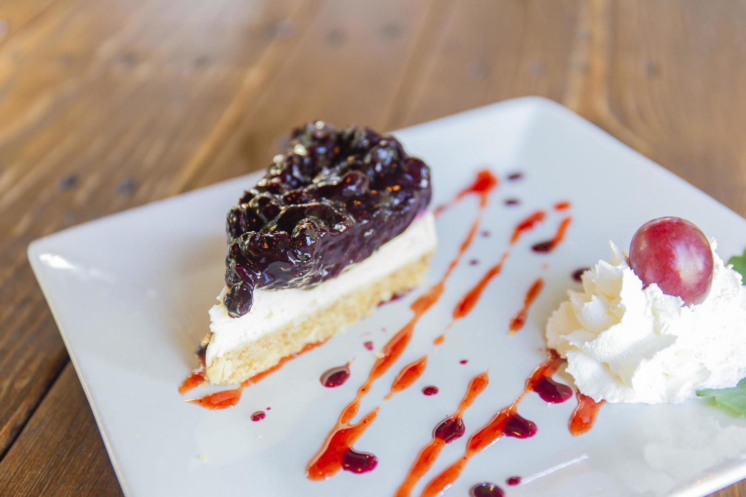 Blueberry cheesecake is arranged in a beautiful plate on wooden table background. photo