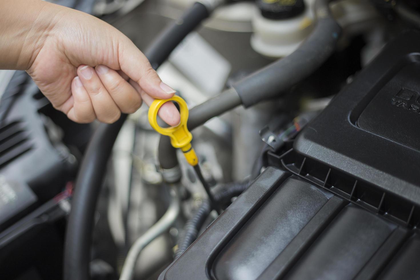 The woman's hand is checking engine open the hood. photo