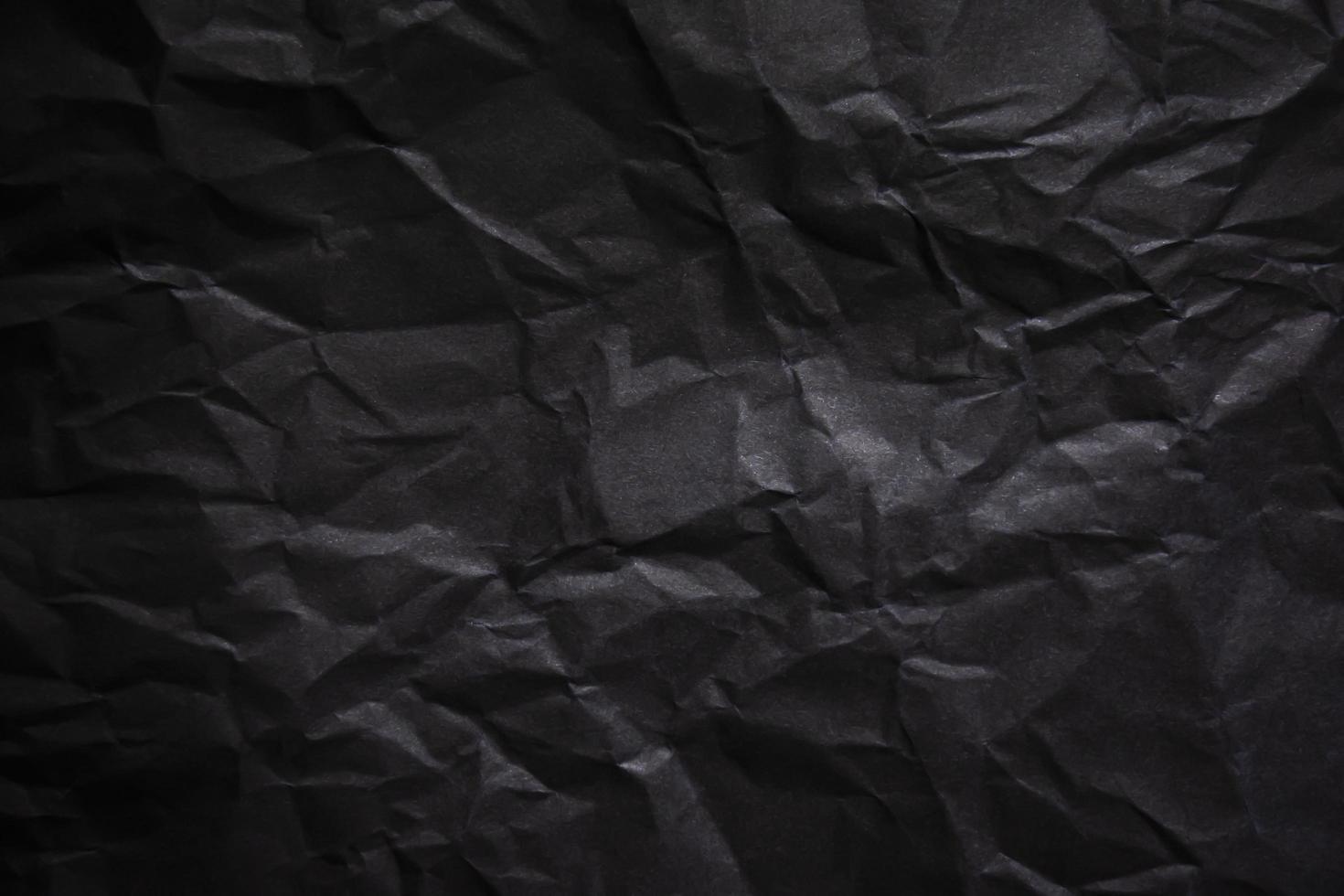 Textured crumpled black paper background. photo