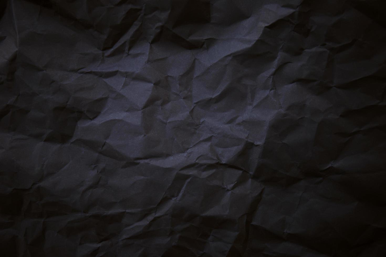 Textured crumpled black paper background. photo