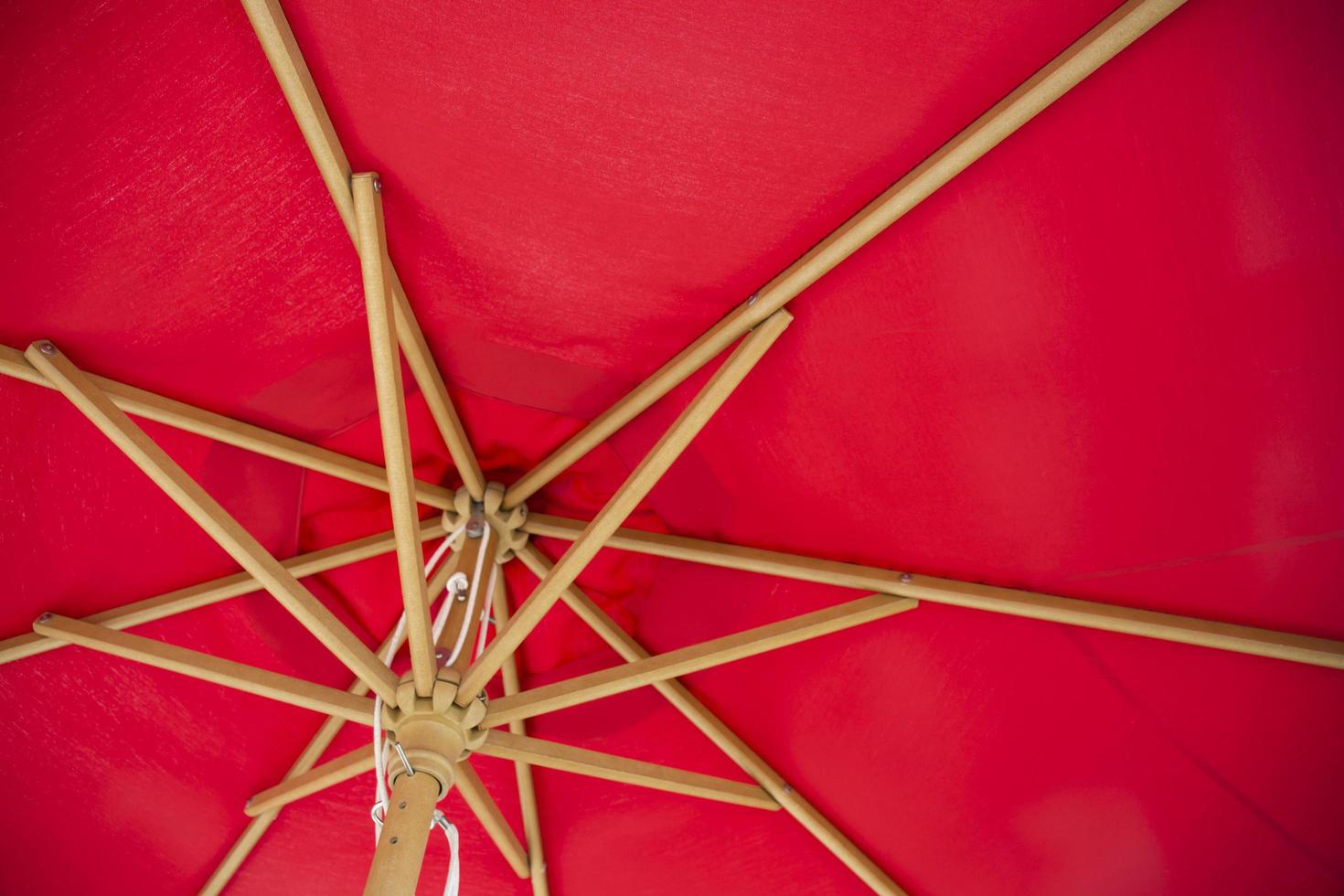 Under red summer parasol with vintage style antique wooden frame. photo