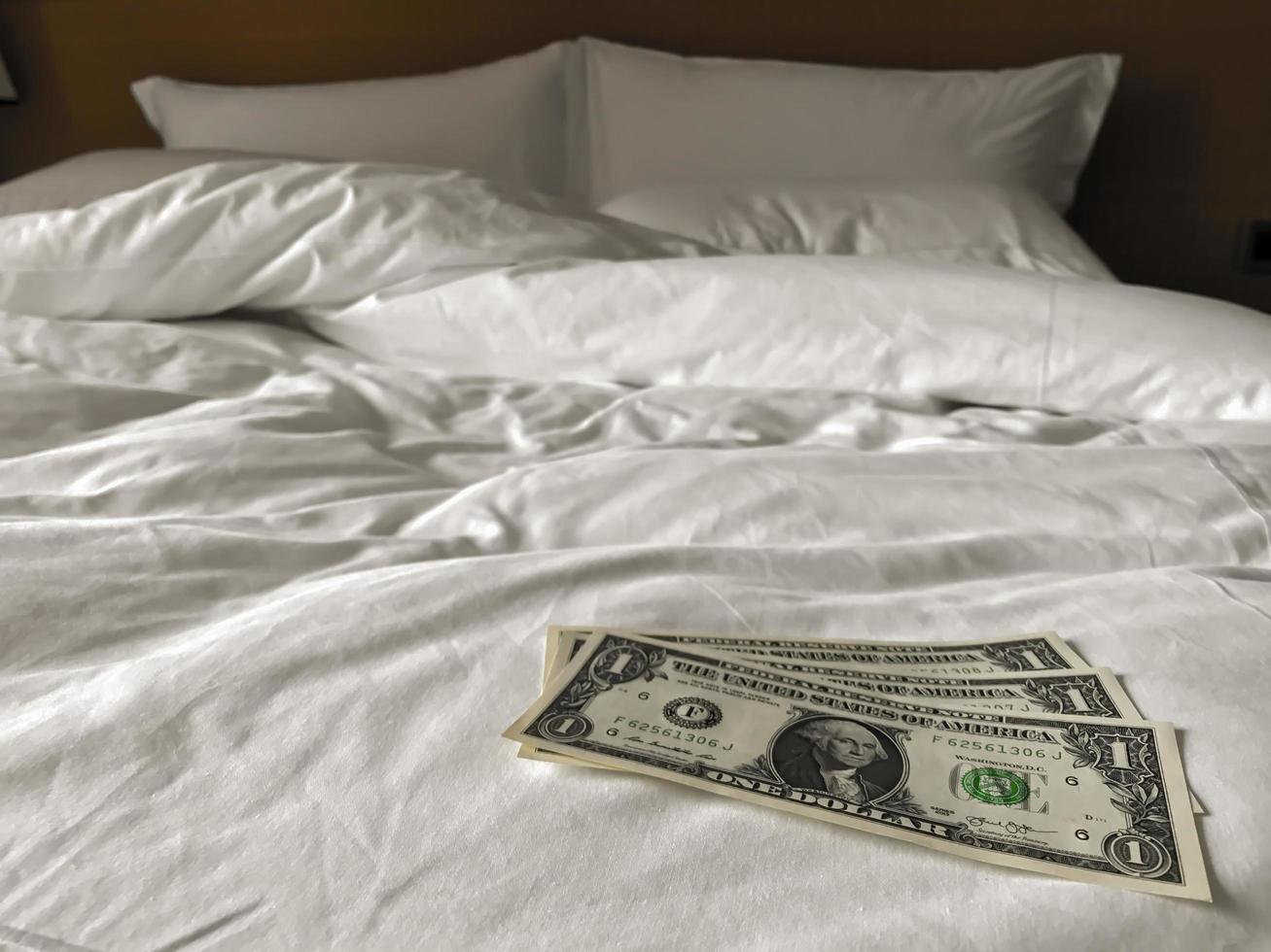 bed and money to symbolize the cost of sex. Paid love the prostitute. Payment for the services of prostitutes. A tip for the staff. buck 1on the bed. monetary gratitude photo