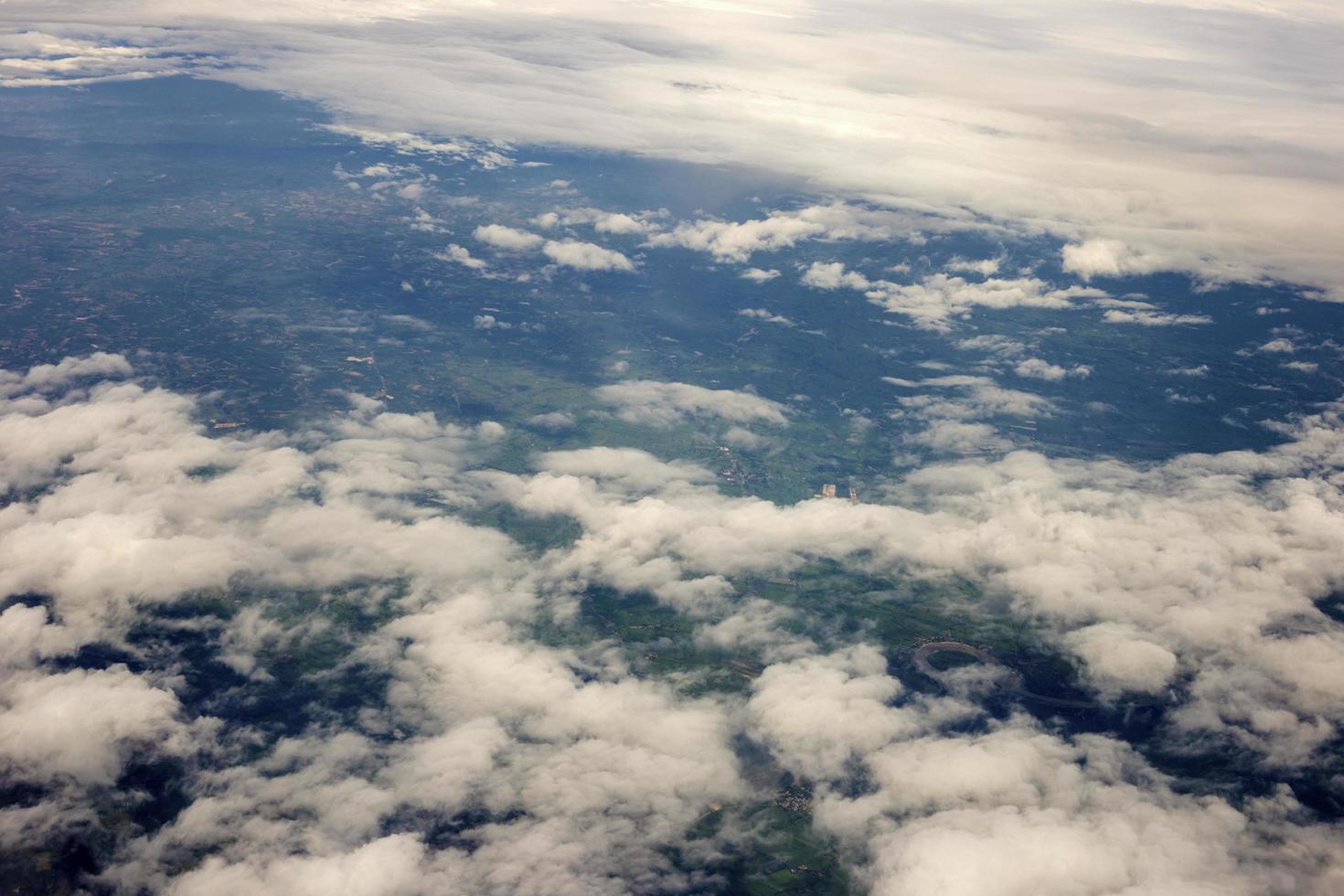 foto aérea desde la ventana del avión, sobre el suelo y la nube, campo verde bajo las nubes