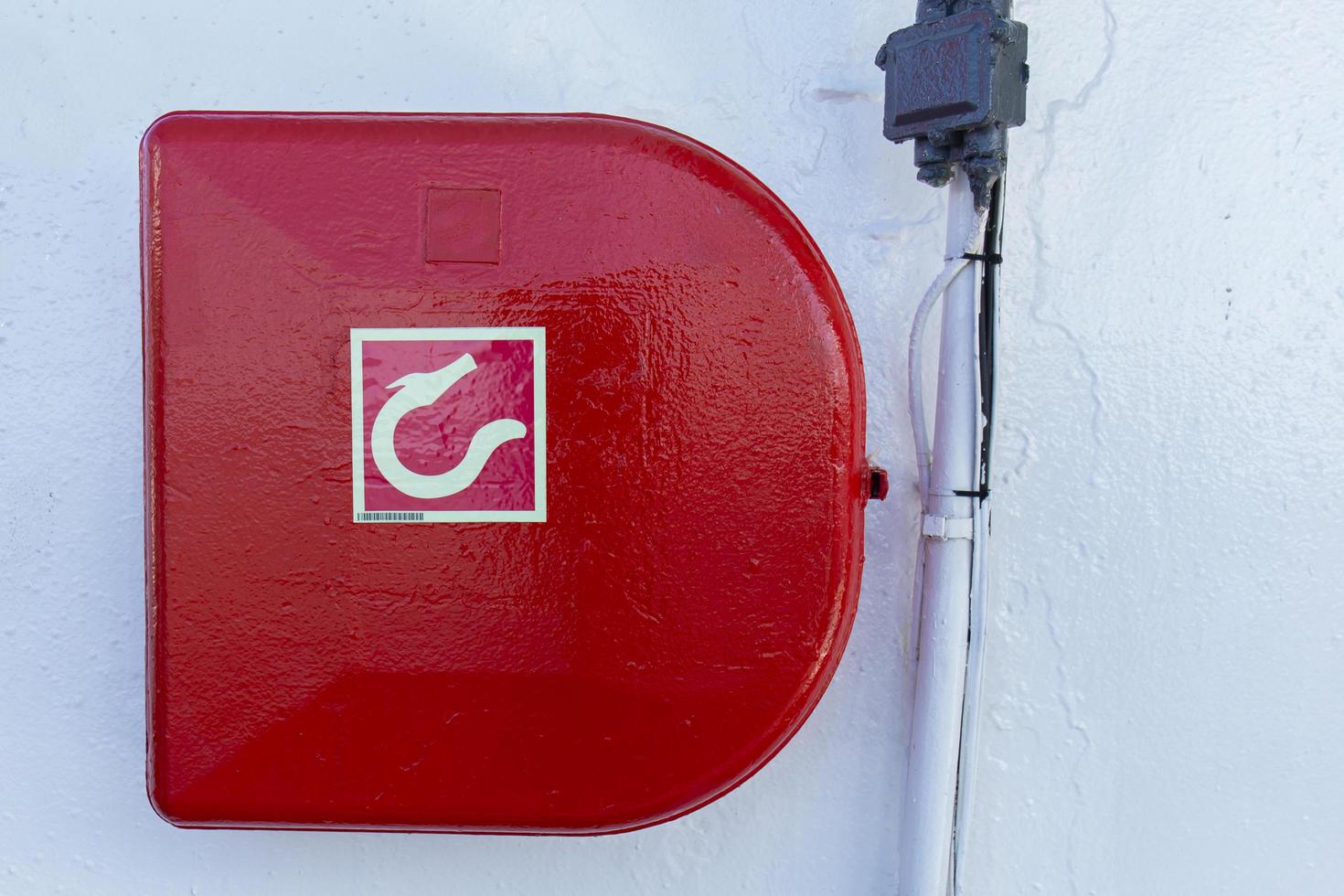 Red fire hose reel attached to the wall on the boat. photo