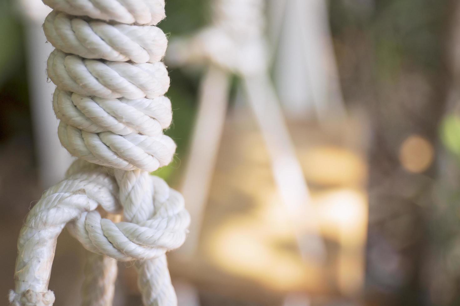 Rope tied in a knot, hanging from a wooden chair. photo