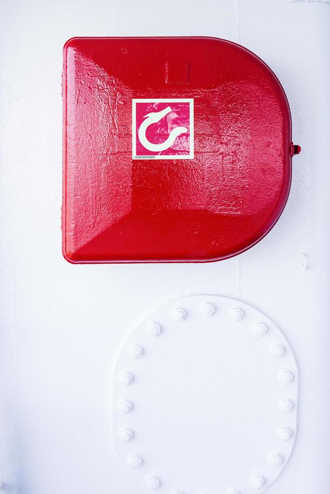 Red fire hose reel attached to the wall on the boat. photo